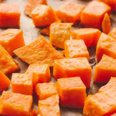 Pokrojone bataty, gotowe do pieczenia. Ich pomarańczowy kolor sugeruje bogactwo beta-karotenu, a bataty właściwości odżywcze czynią je zdrowym dodatkiem do diety.