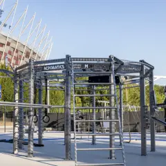 Zewnętrzna siłownia z konstrukcją do ćwiczeń, workiem treningowym i tablicą Multisport.