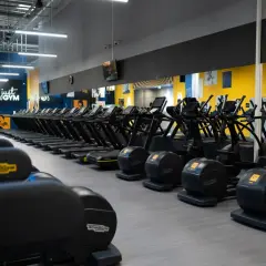 Rzędy bieżni i orbitreków w siłowni Just Gym. Dowiedz się, jak wejść na Multisport i zacząć trening.
