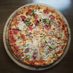 Pół na pół: pizza z salami i jalapeno oraz z szynką i pieczarkami. Zastanawiasz się, ile kalorii ma kawałek pizzy?