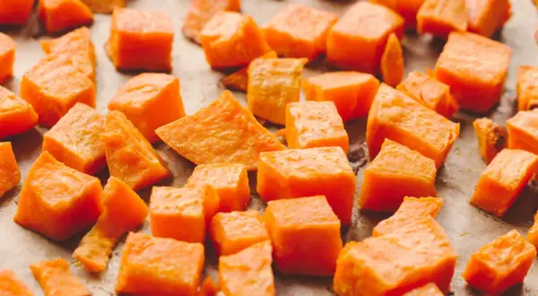 Pokrojone bataty, gotowe do pieczenia. Ich pomarańczowy kolor sugeruje bogactwo beta-karotenu, a bataty właściwości odżywcze czynią je zdrowym dodatkiem do diety.