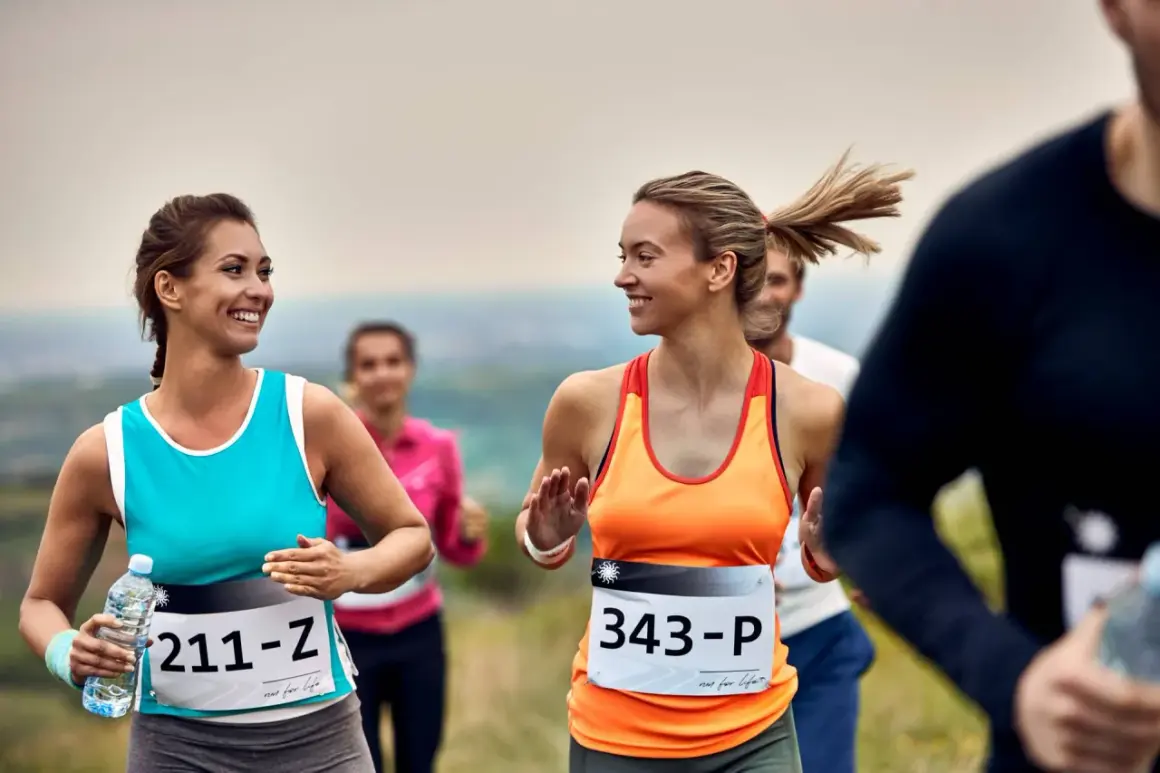 Uśmiechnięte kobiety biegną w półmaratonie. Ile km jeszcze do mety?