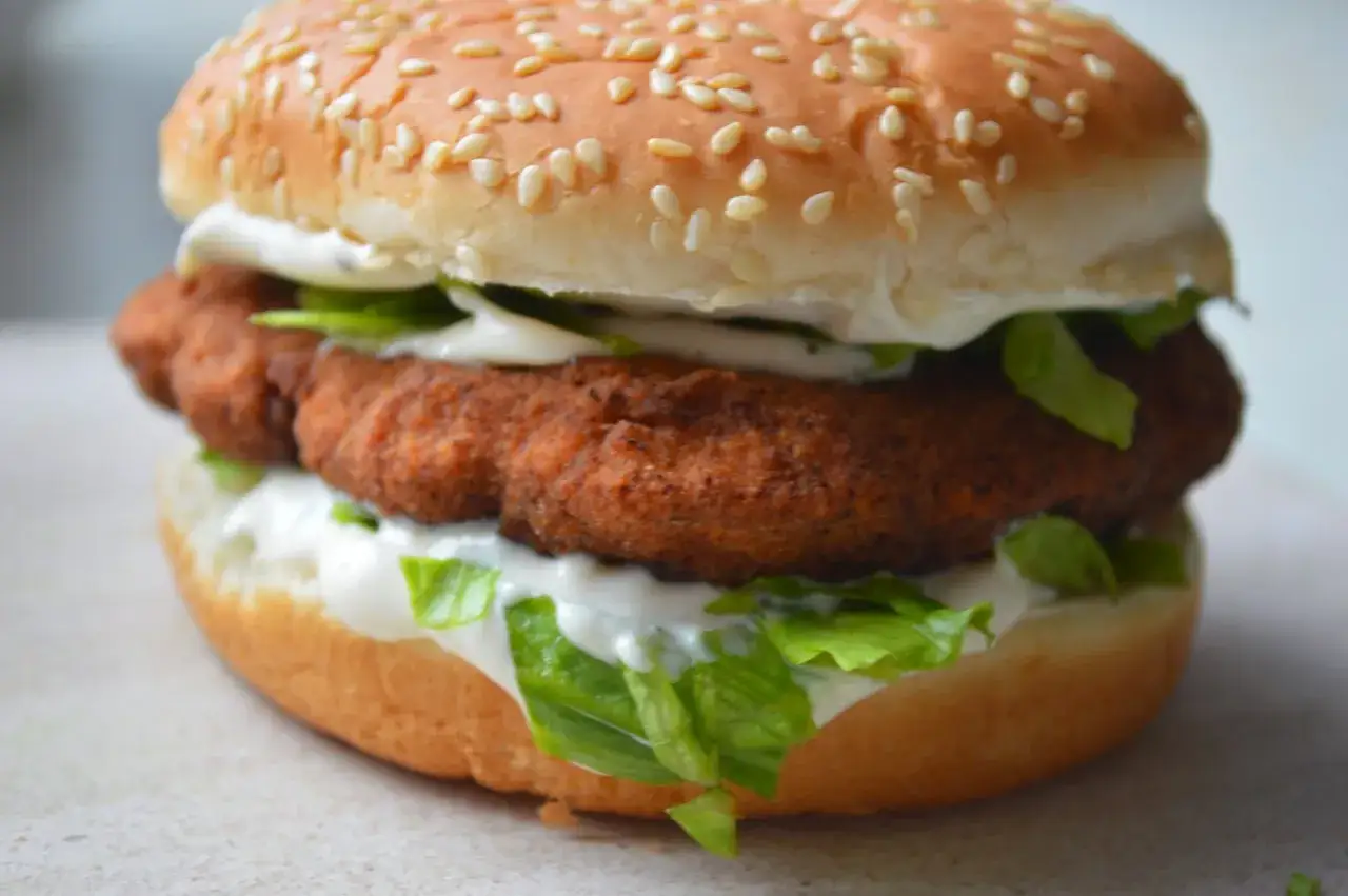 McChicken ma około 400 kcal. Burger z chrupiącym kurczakiem, sałatą i sosem na bułce z sezamem.